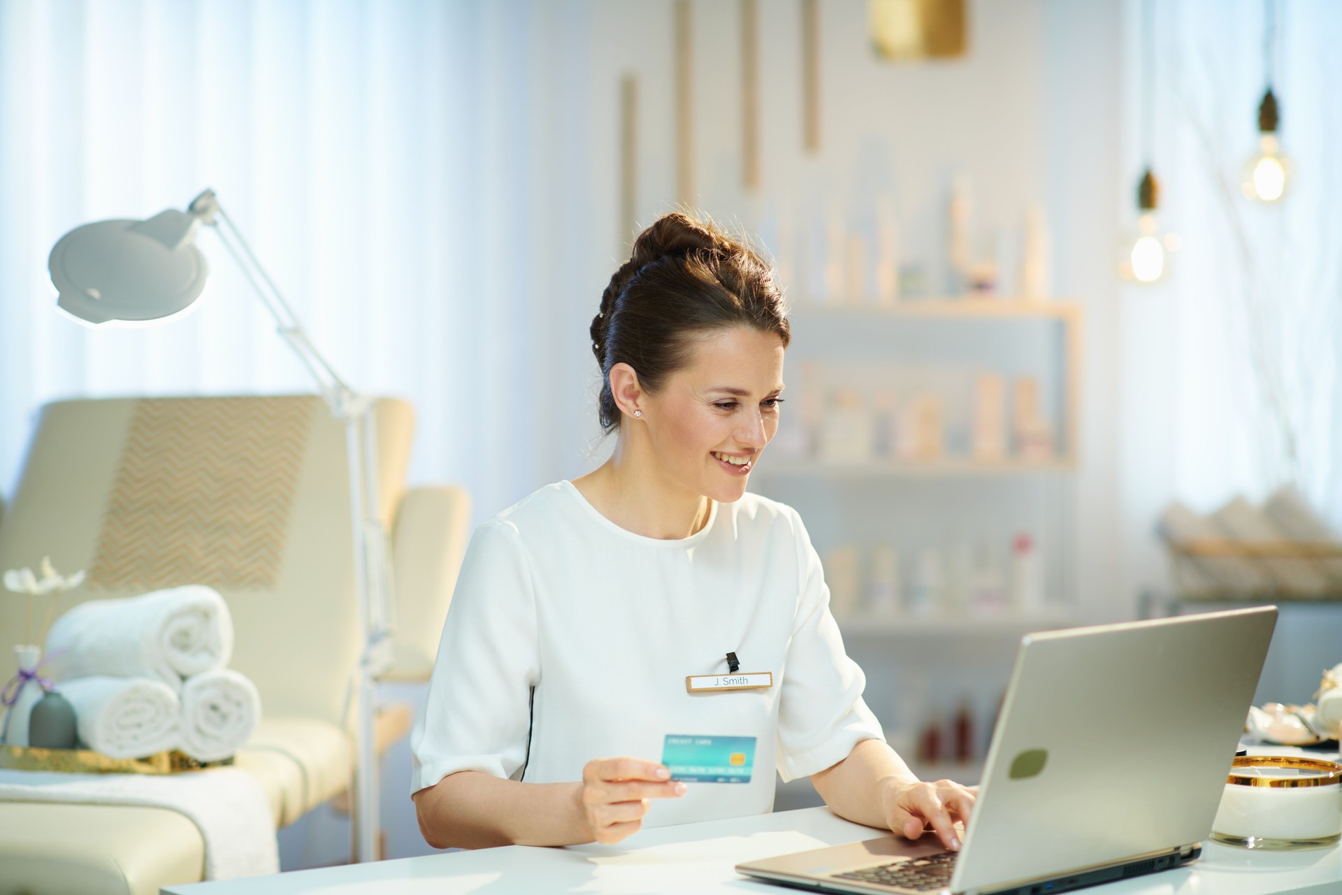 happy 40 years old woman employee in beauty salon buying online